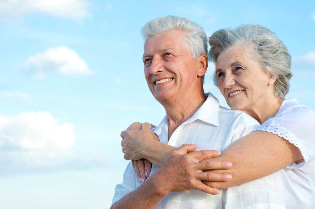 an elderly couple smiling after their all-on-4 dental implant procedure