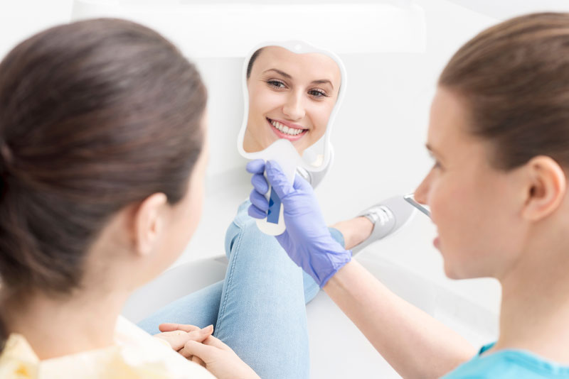 a dental implant patient smiling after implant surgery under sedation