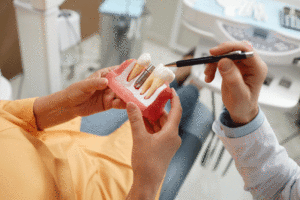 Woman holding tooth model during consultation on dental implant.